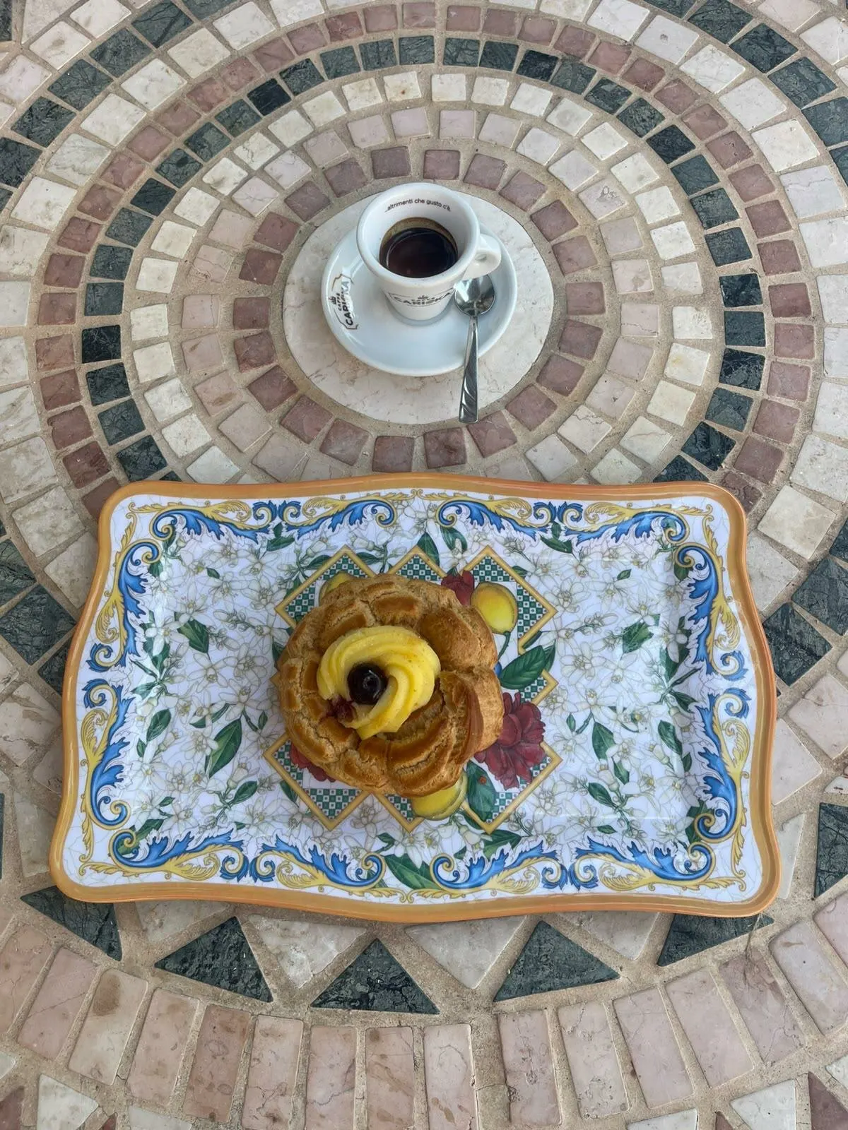 Un dolce e il caffè sul tavolo in mosaico